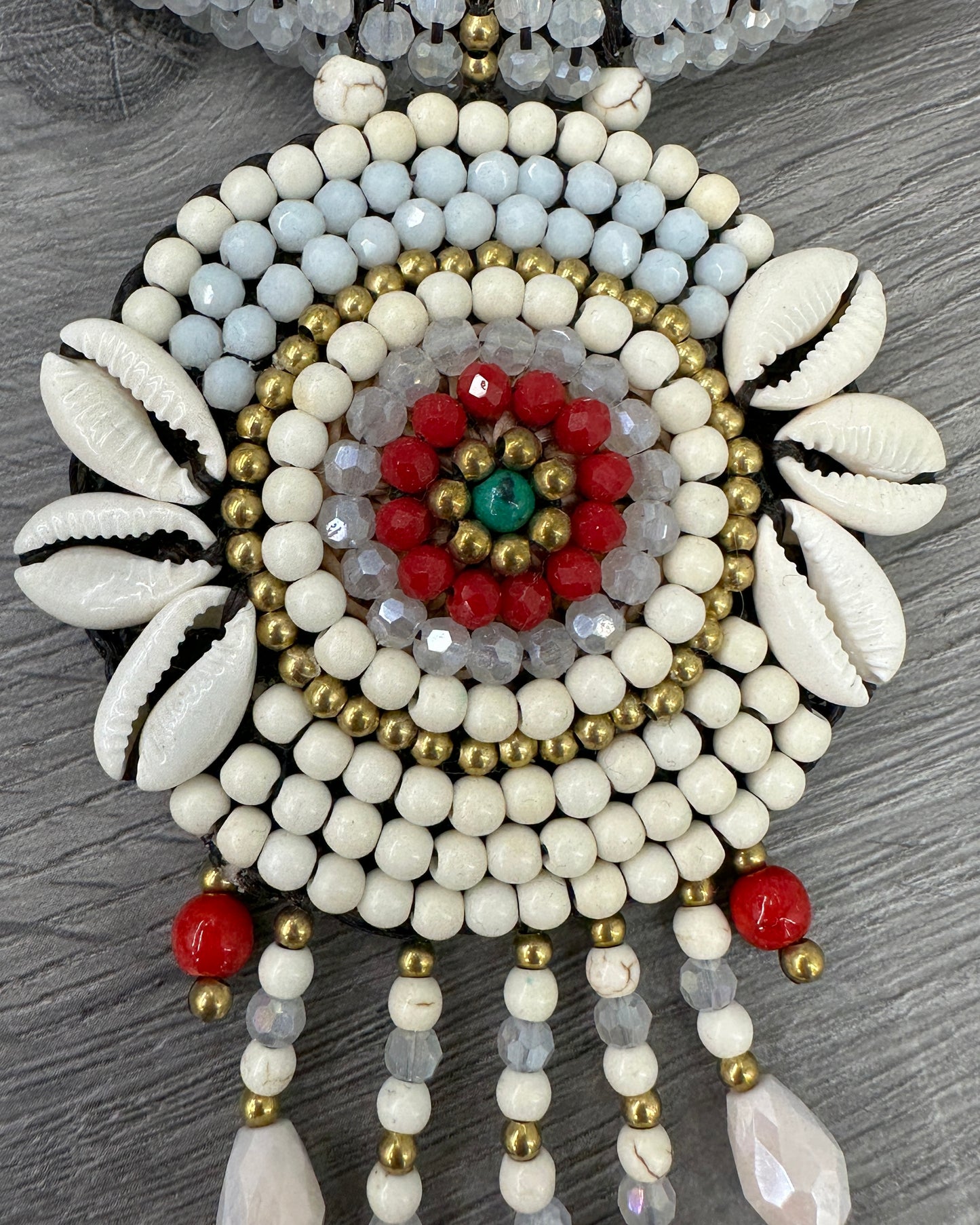 Dettaglio collana boho chic bianca con conchiglie naturali, cristalli e grande pendente artigianale