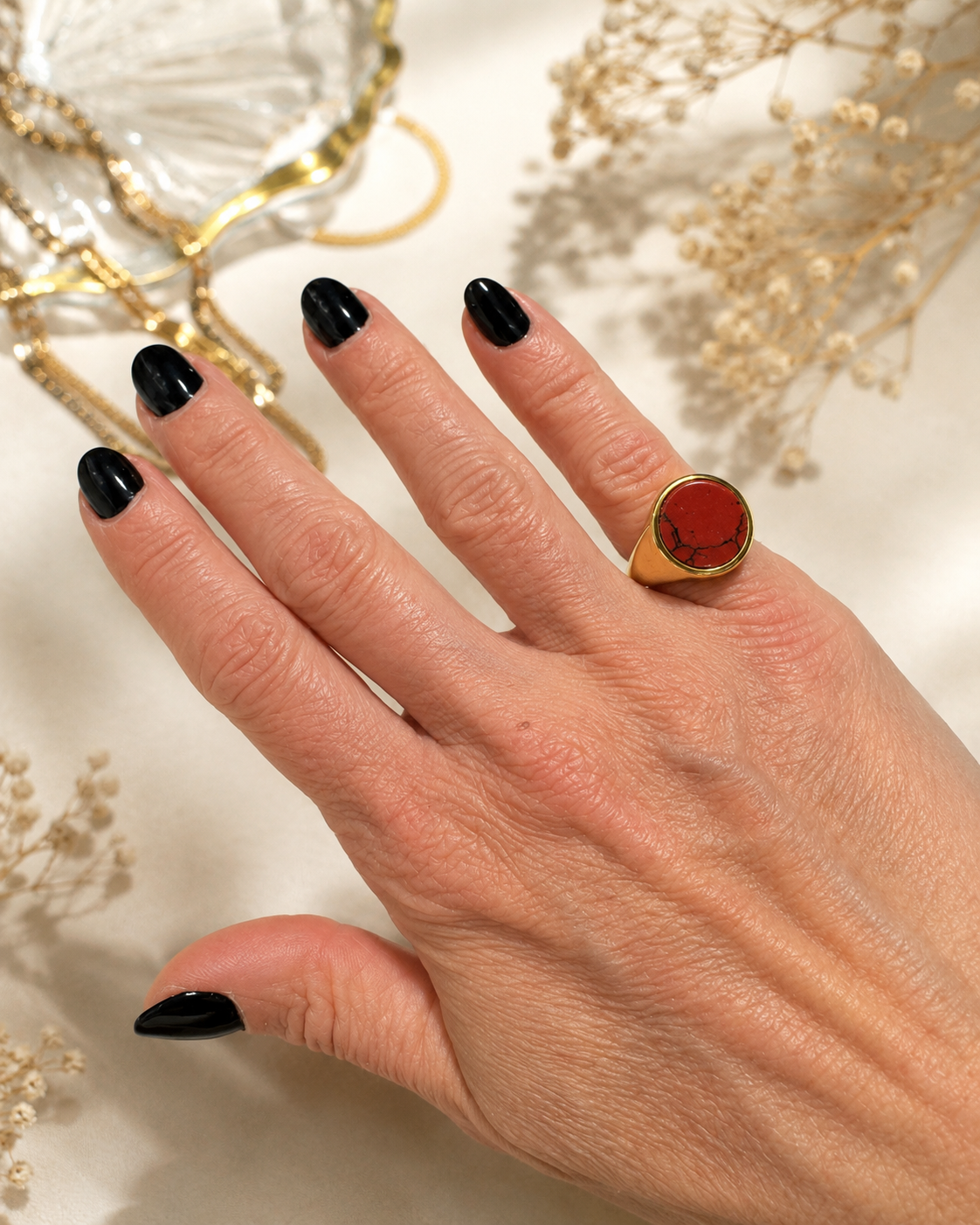 Anello chevalier dorato con diaspro rosso naturale venato indossato su mano