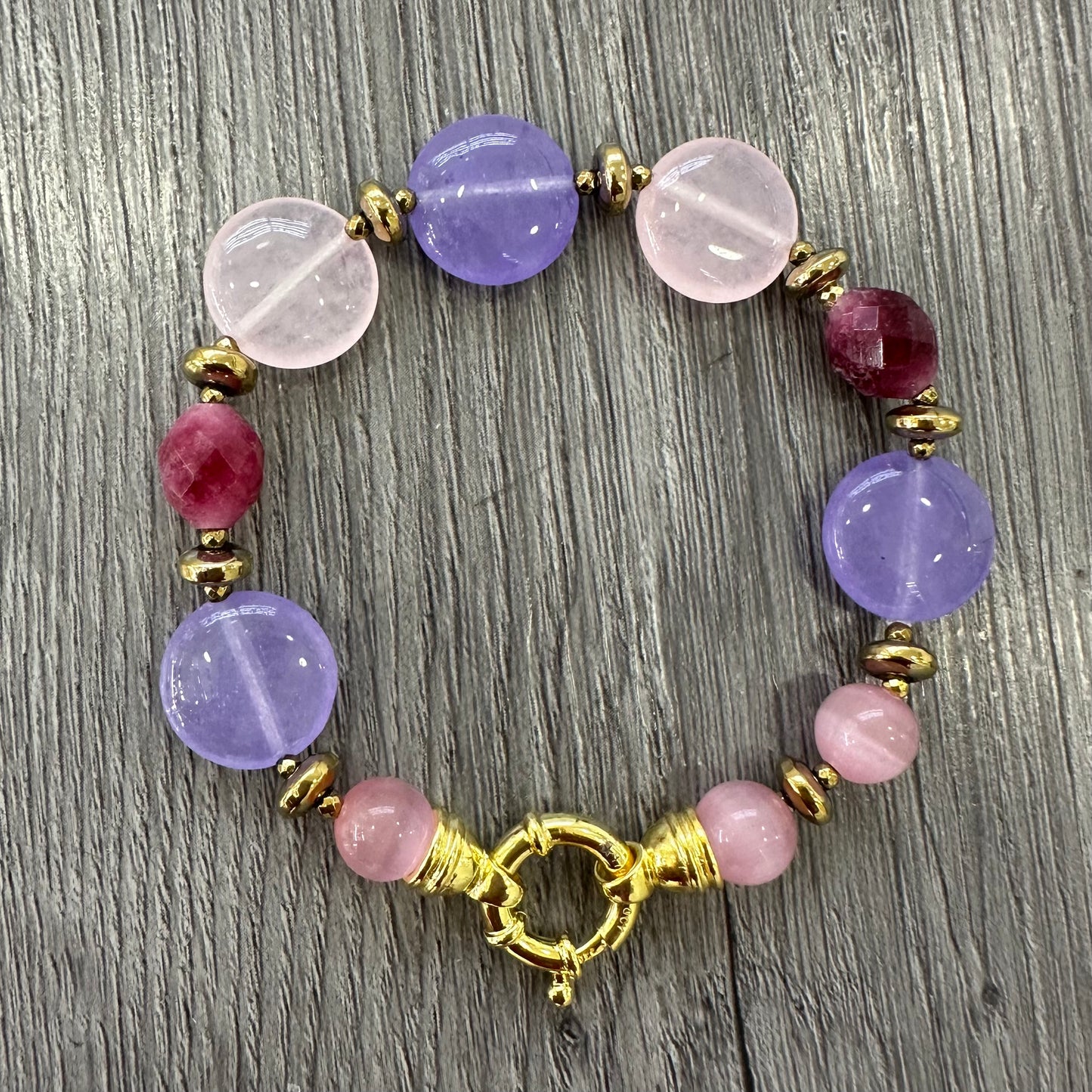 Bracciale artigianale con giada viola e rosa, tormalina rossa, ematite dorata e chiusura in argento placcato oro