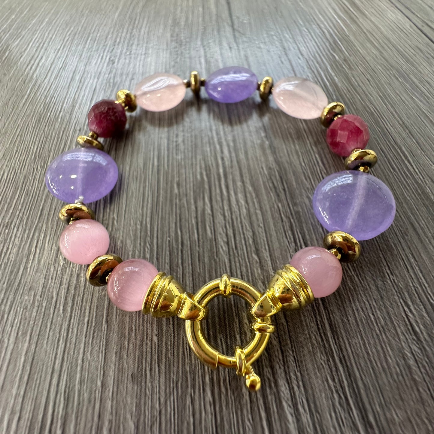 Bracciale artigianale con giada viola e rosa, tormalina rossa, ematite dorata e chiusura in argento placcato oro