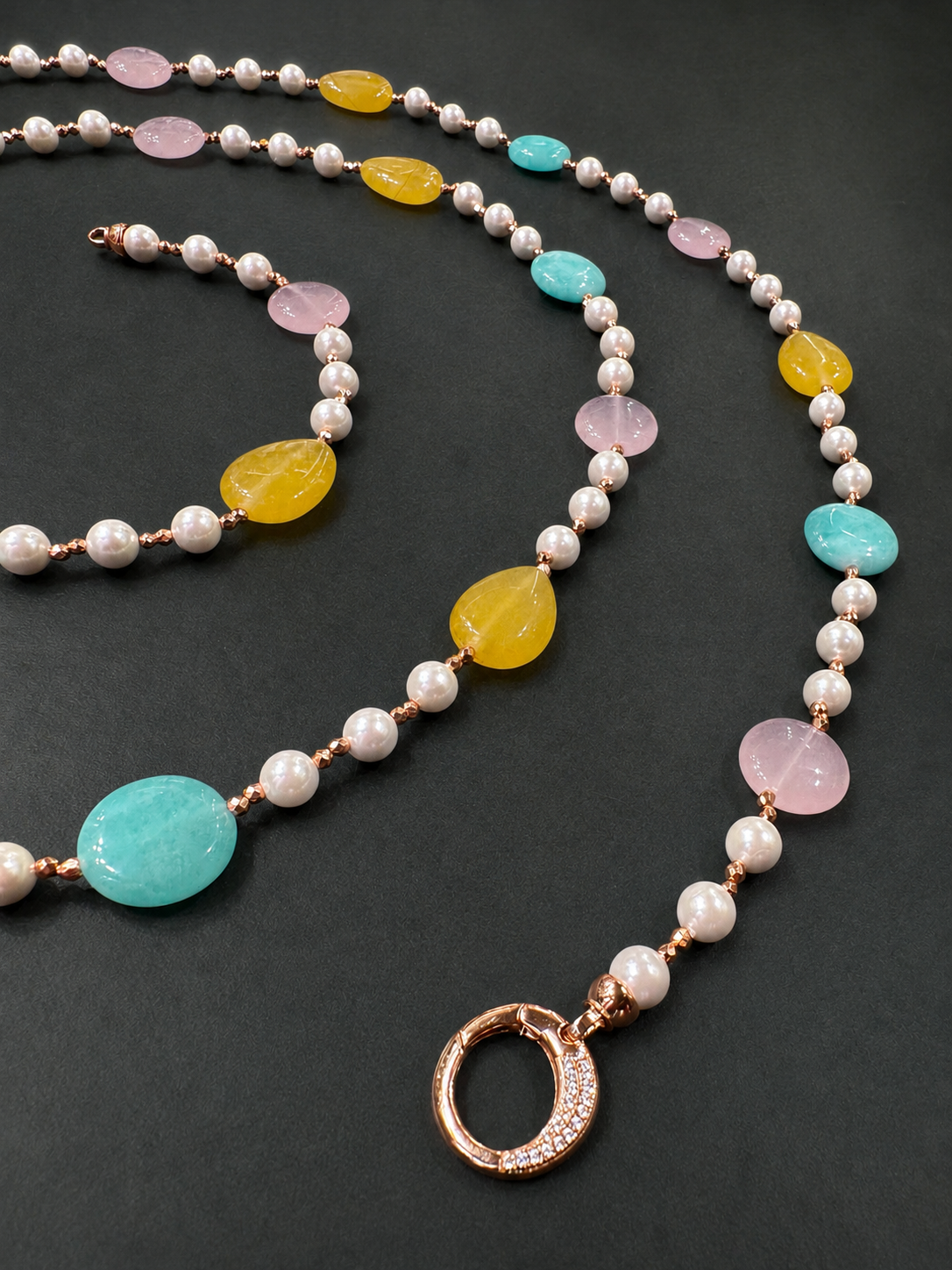 Dettaglio Collana artigianale con giada pastello, perle di Maiorca, ematite rosata e chiusura in argento rosato su fondo scuro