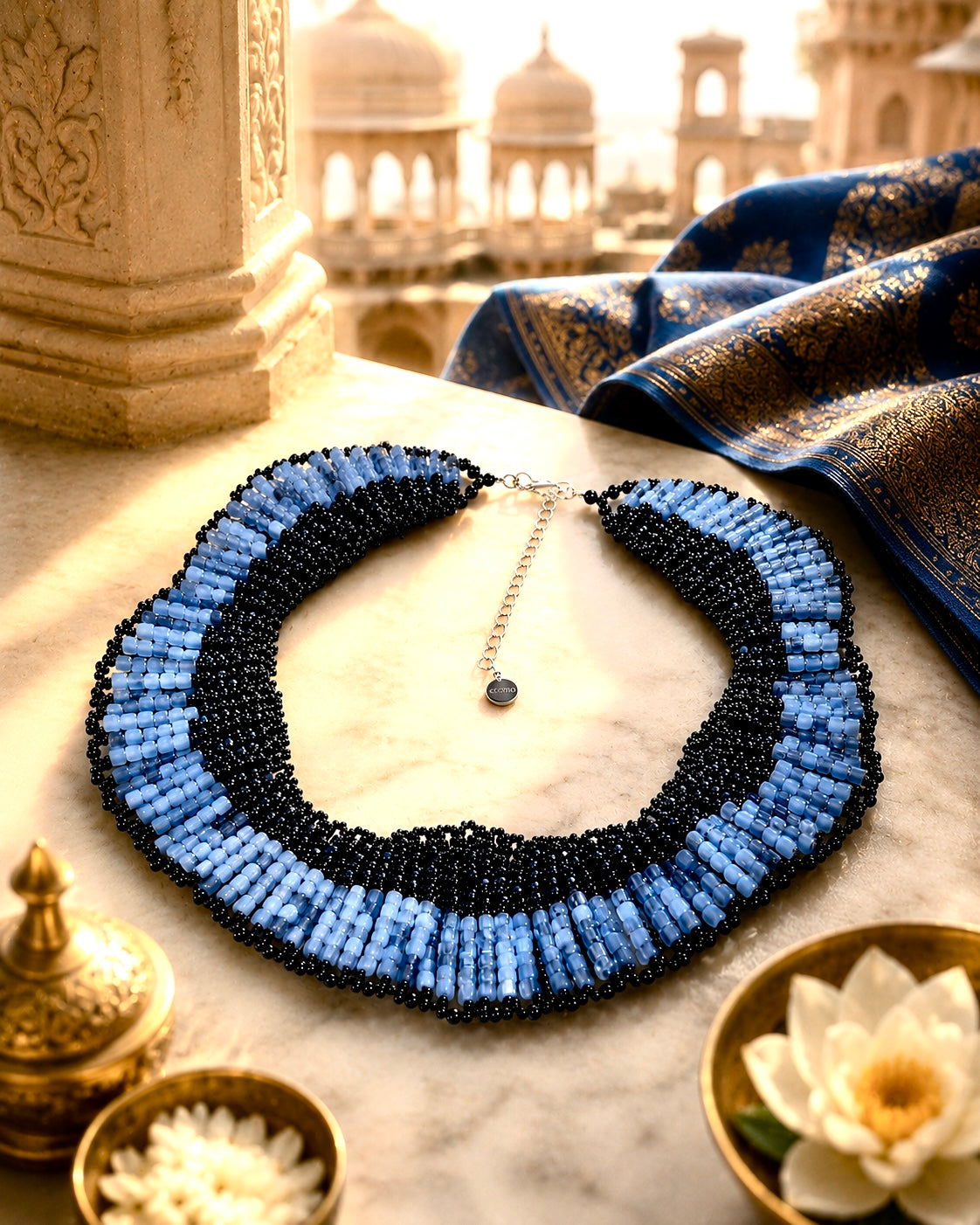 Collana ricamata con perline blu e nere e cristalli in un’ambientazione ispirata all’India.