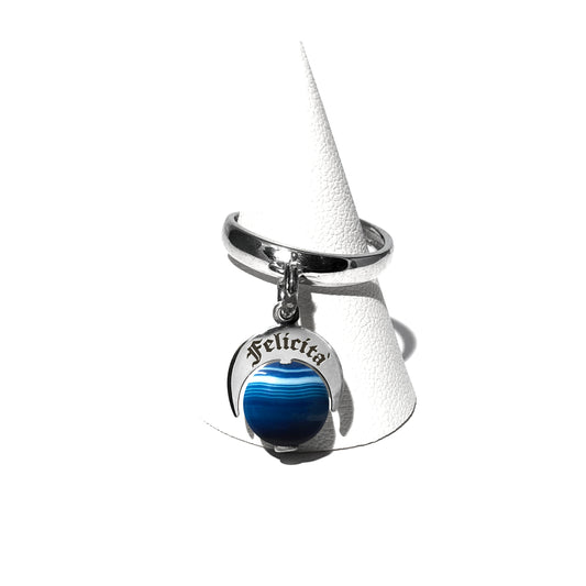 Caratteristiche: L'anello è composto da una base in Argento 925 e un Charm Naja. Quest'ultimo è inciso e smaltato, con scritte in carattere gotico e una Pietra Dura. Il Charm è attaccato alla base dell'anello con un piccolo moschettone che permette l'eventuale riposizionamento del charm stesso su un bracciale , una collana o un qualsiasi altro supporto.