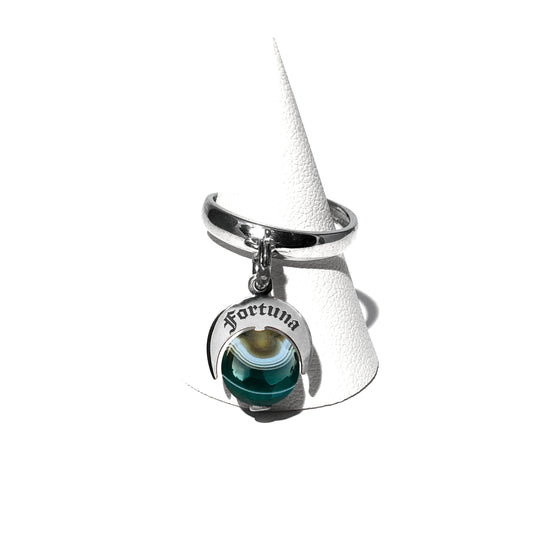 Caratteristiche: L'anello è composto da una base in Argento 925 e un Charm Naja. Quest'ultimo è inciso e smaltato, con scritte in carattere gotico e una Pietra Dura. Il Charm è attaccato alla base dell'anello con un piccolo moschettone che permette l'eventuale riposizionamento del charm stesso su un bracciale , una collana o un qualsiasi altro supporto