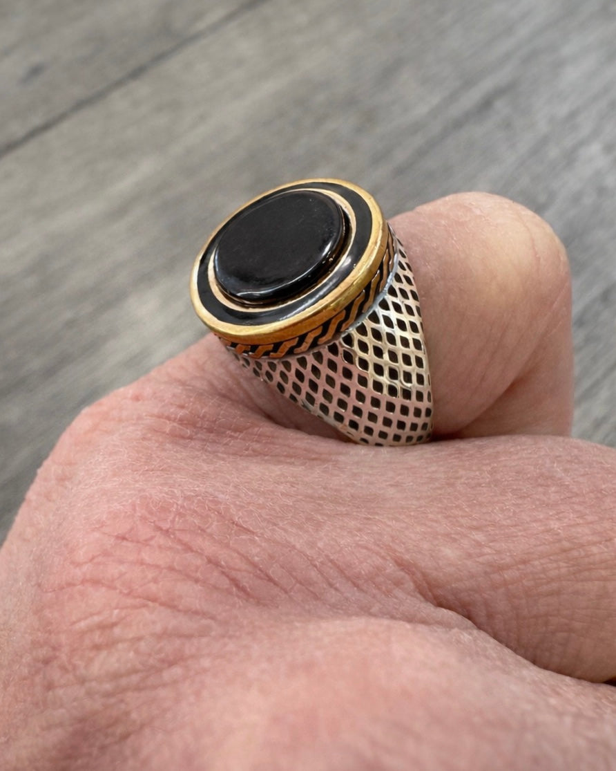 Anello uomo argento 925 con pietra nera onice e dettagli dorati indossato su mano
