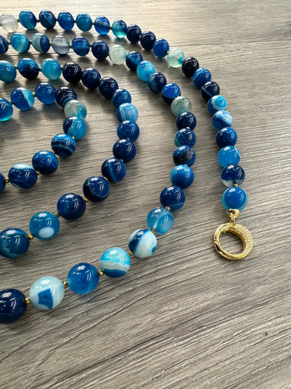 Dettaglio di collana lunga agata striata blu e argento dorato