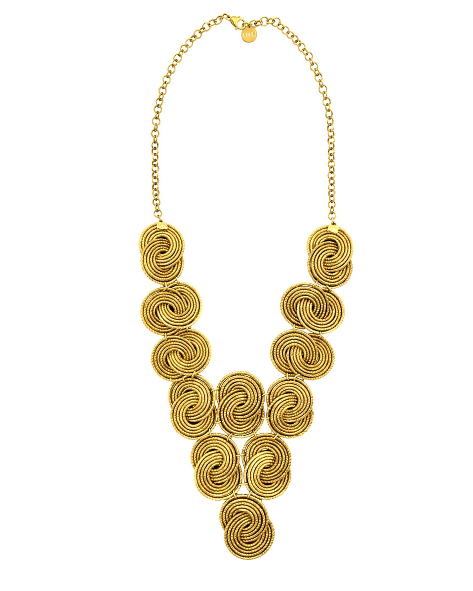     Collana in Capim Dourado intrecciata a mano con elementi spiralati e catena in acciaio dorato su sfondo bianco