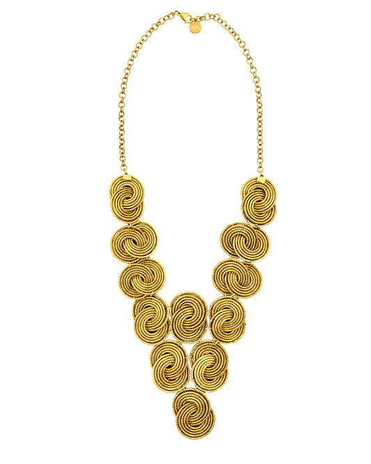     Collana in Capim Dourado intrecciata a mano con elementi spiralati e catena in acciaio dorato su sfondo bianco