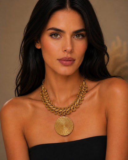 Collana Capim Dourado con ciondolo tondo intrecciato indossata su modella, gioiello artigianale oro vegetale elegante Attimi Gioielli
