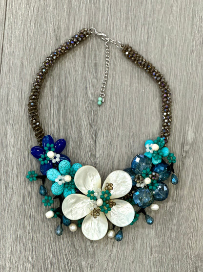 Collana floreale artigianale con madreperla, cristalli blu e pietre turchesi