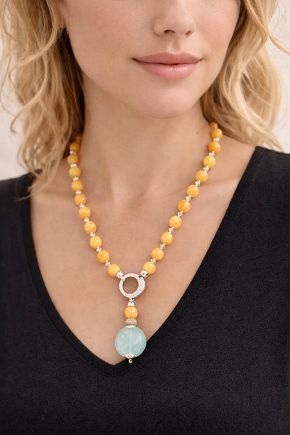 Collana in giada gialla con cristalli Swarovski e pendente in giada azzurra montato su argento 925 indossata su modella con abito nero.