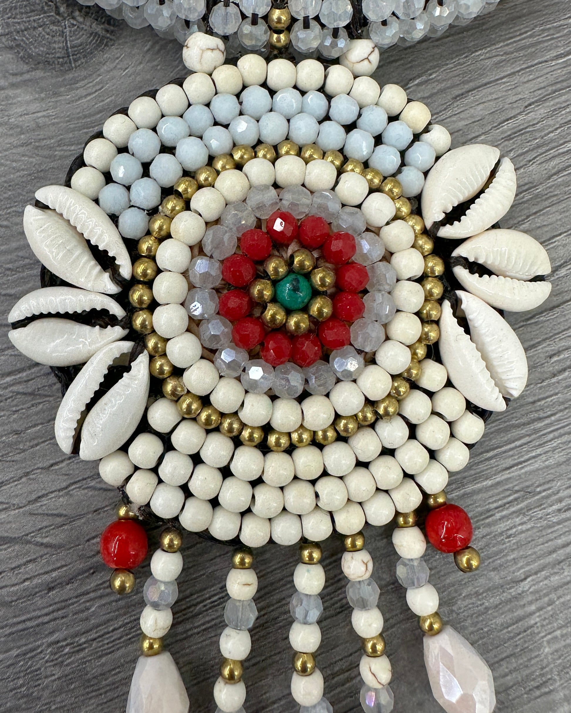 Dettaglio collana boho chic bianca con conchiglie naturali, cristalli e grande pendente artigianale