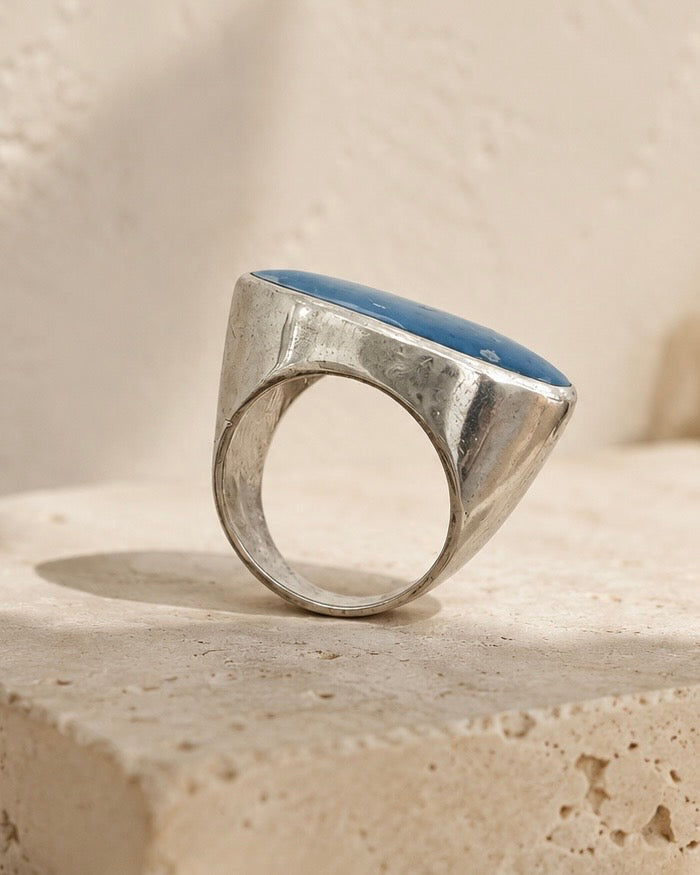     Anello artigianale in Argento 925 con Agata blu ambientato su travertino