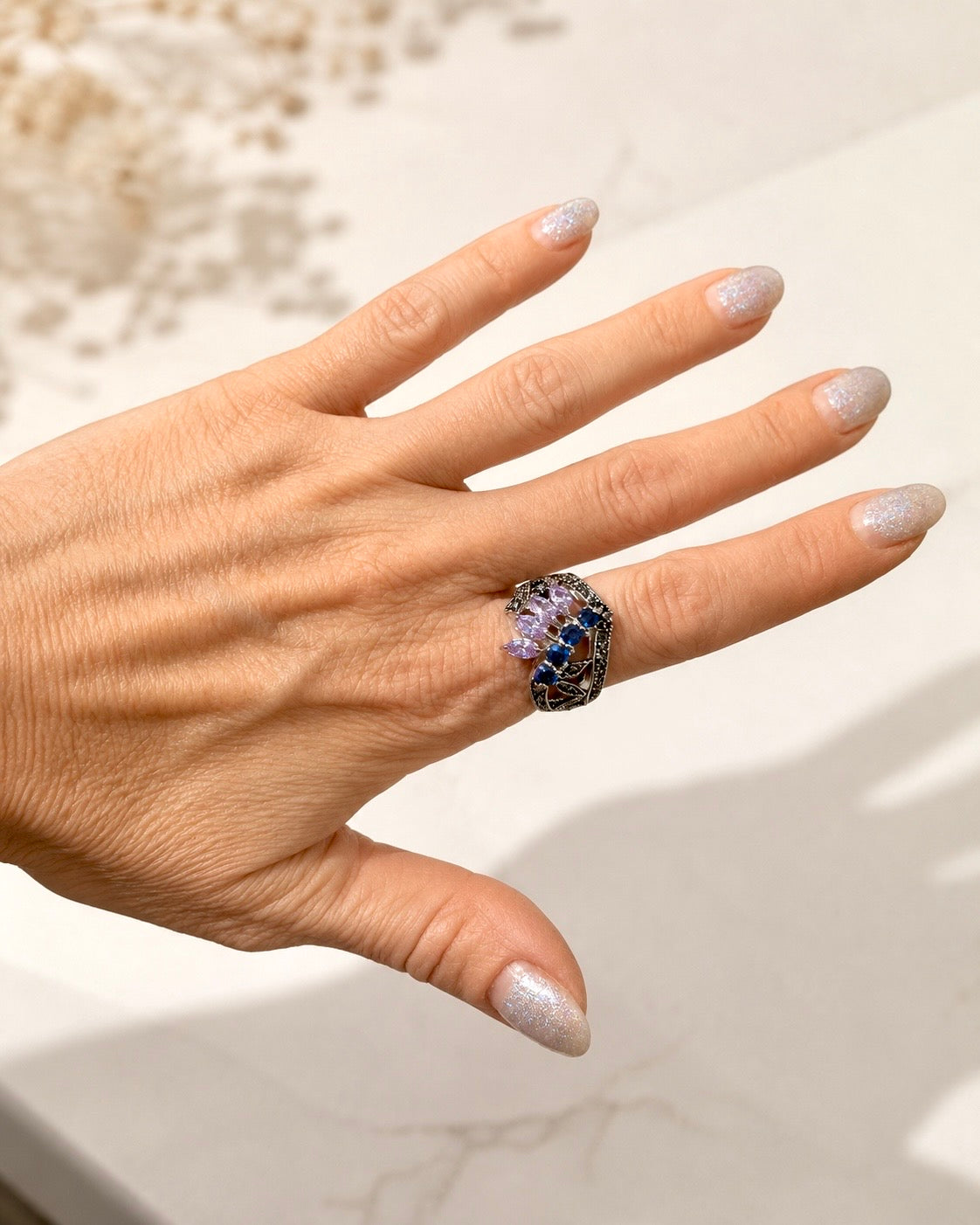 Anello in Argento 925 con ametista e zirconi blu indossato sulla mano.