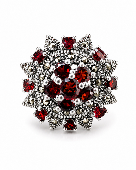 Anello floreale in argento 925 con granati naturali e marcasiti su fondo bianco.
