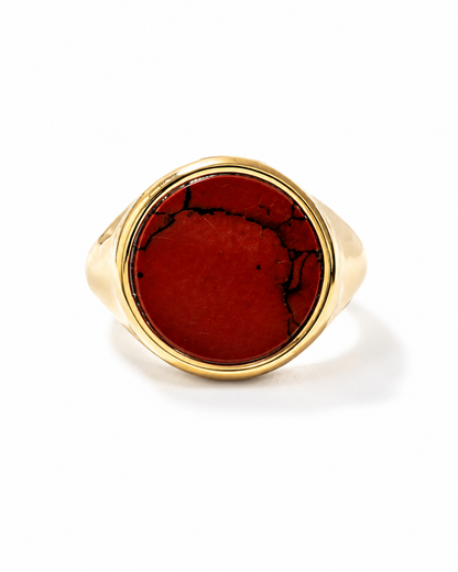 Anello chevalier in argento dorato con pietra naturale diaspro rosso e venature nere su sfondo bianco minimal