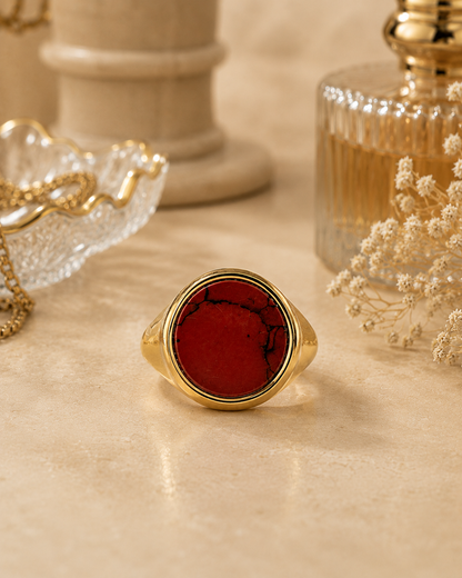Anello chevalier dorato con diaspro rosso naturale e venature nere, fotografia frontale con dettagli luxury 