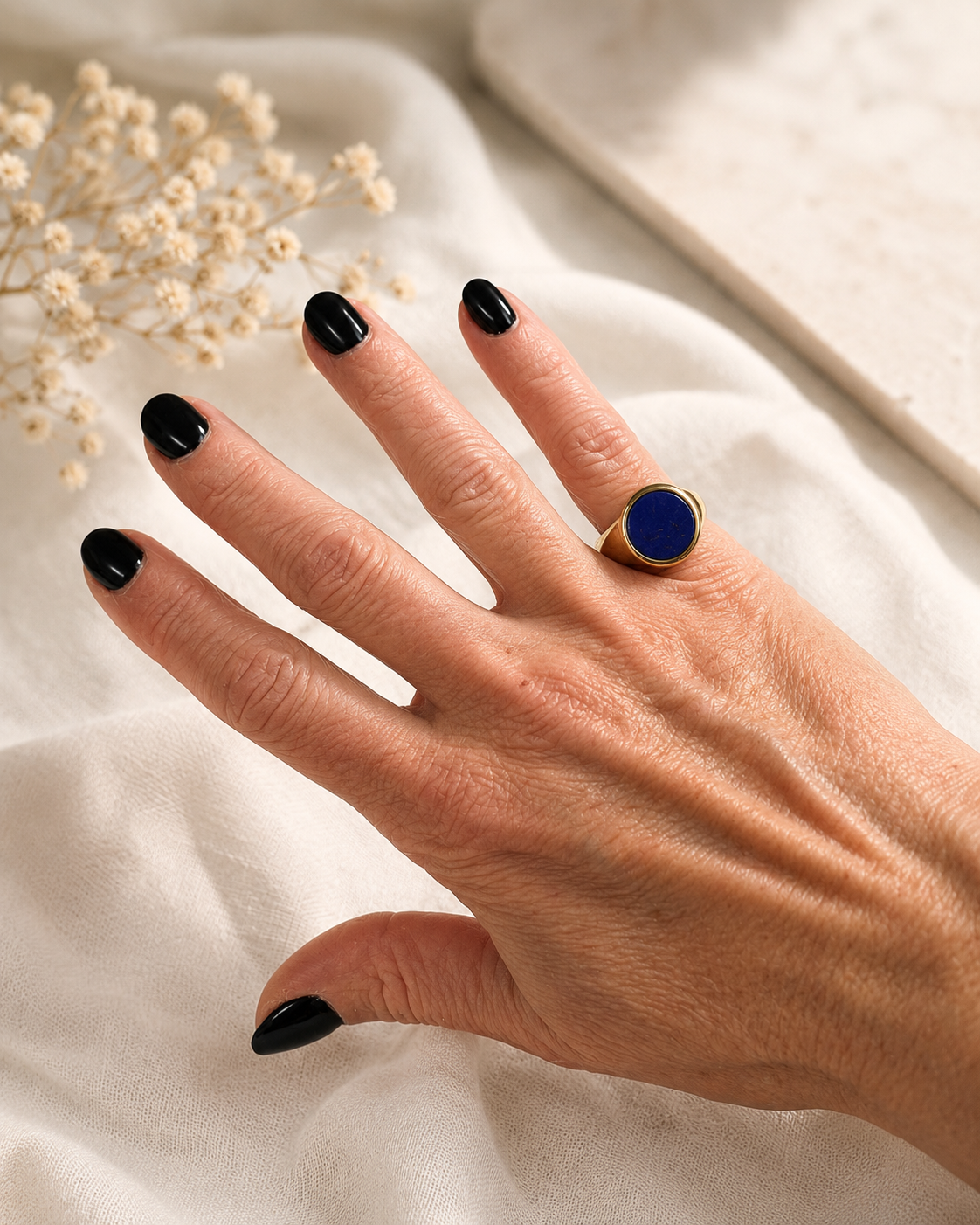 Anello chevalier dorato con pietra blu lapis indossato su mano Stile elegante contemporaneo