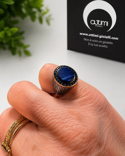 Anello chevalier elegante in argento 925 con pietra blu ovale indossato su mano in luce naturale