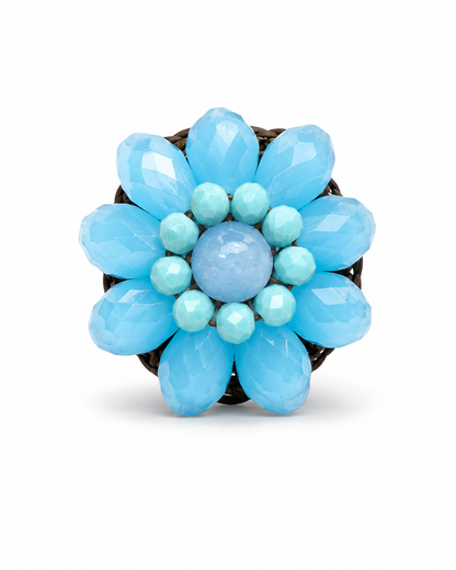 Anello artigianale regolabile con cristalli azzurri sfaccettati e cordino intrecciato in cotone cerato idrorepellente.