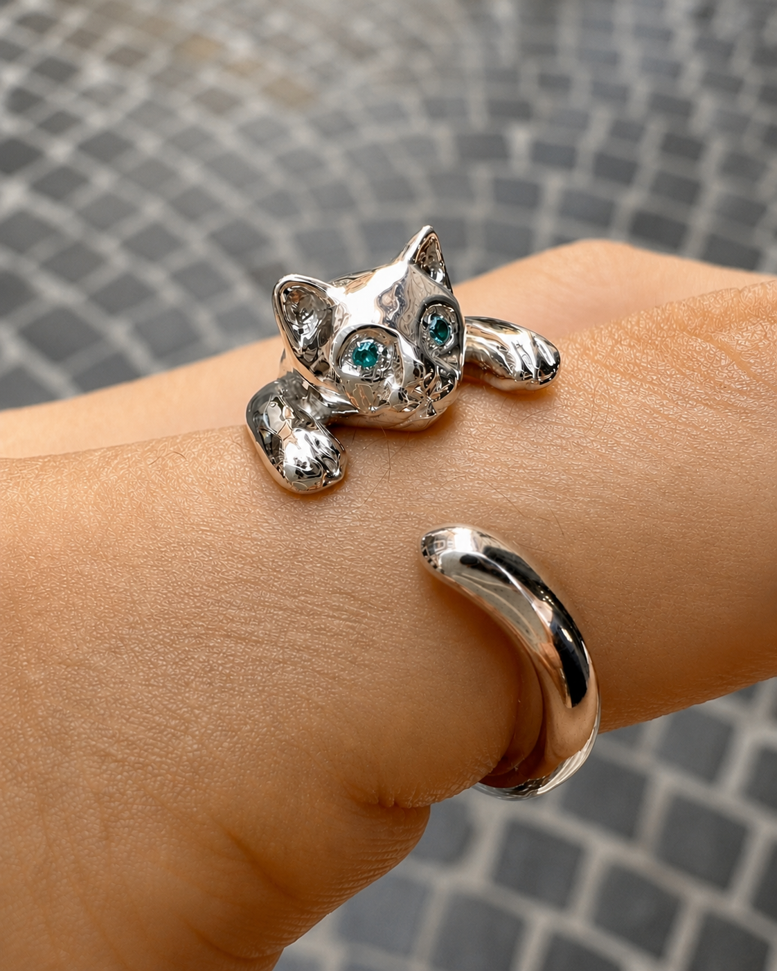 Anello gatto in argento 925 con occhi verde acqua indossato su mano, gioiello artigianale regolabile dal design originale.