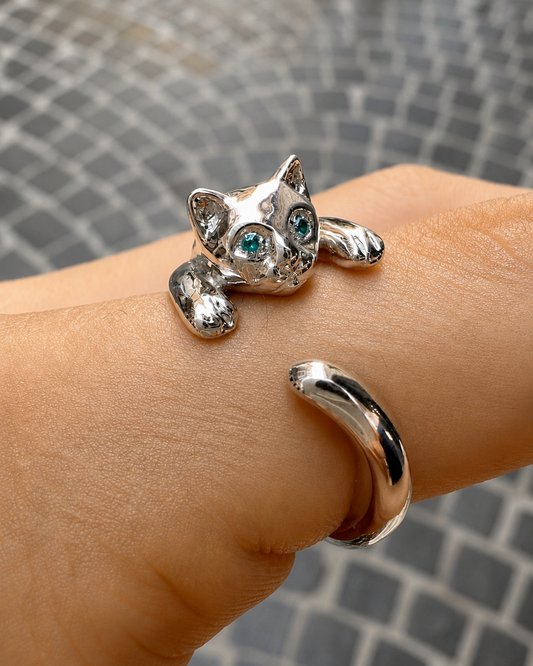 Anello gatto in argento 925 con occhi verde acqua indossato su mano, gioiello artigianale regolabile dal design originale.