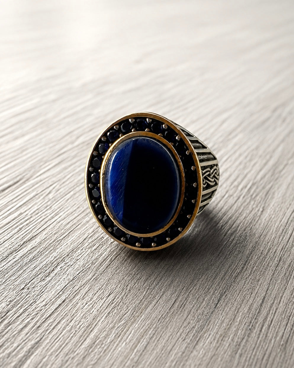     Primo piano di anello da mignolo argento 925 con pietra blu ovale lucida e texture vintage