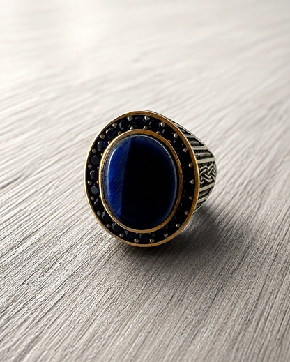     Primo piano di anello da mignolo argento 925 con pietra blu ovale lucida e texture vintage