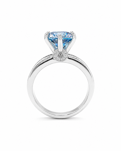 Anello in argento 925 con moissanite color acquamarina taglio brillante, vista laterale, finitura lucida, sfondo bianco.
