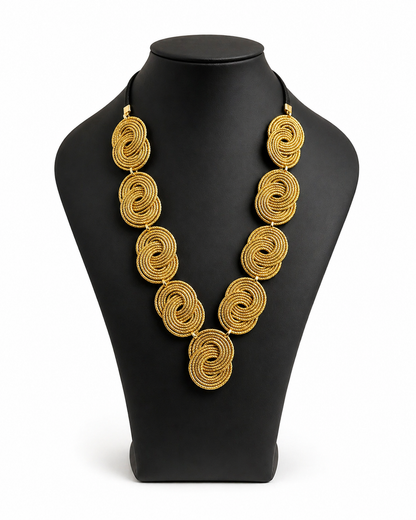 Dettaglio Collana intrecciata in capim dourado oro vegetale fatta a mano design a spirale Attimi Gioielli