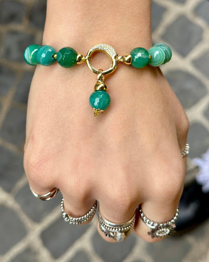     Modella che indossa un bracciale artigianale in Agata Brasiliana striata verde con dettagli in Argento 925 dorato, zirconi ed Ematite dorata.