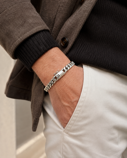 Bracciale Cuban Link in Argento 925 indossato da uomo con outfit elegante casual nei toni beige e nero, stile luxury contemporaneo.