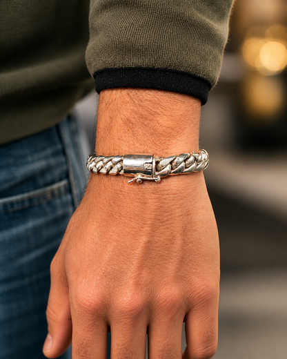 Bracciale Cuban Link uomo in Argento 925 con maglia intrecciata e chiusura decorata, indossato da modello in stile casual luxury.