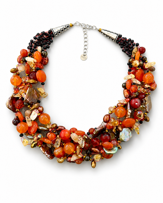 Collana artigianale arancio multifilo con pietre naturali e perle su sfondo bianco, gioiello Attimi Gioielli