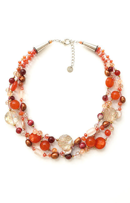Collana artigianale intrecciata con pietre naturali nei toni arancio, perle e cristalli, design multistrato elegante