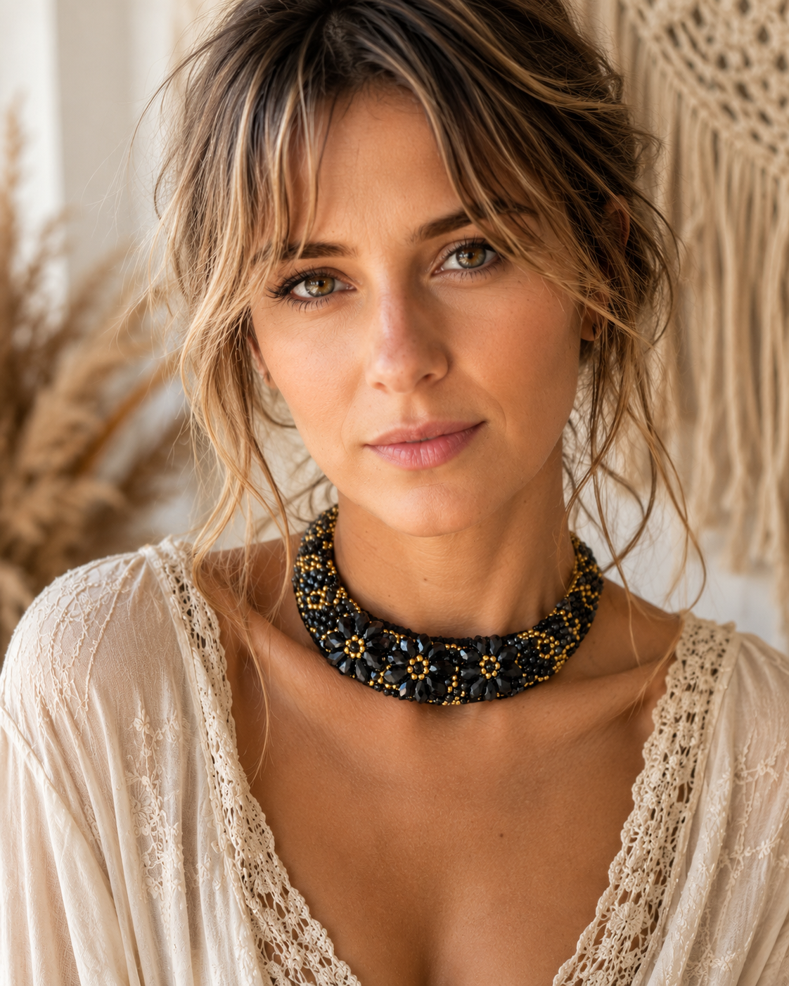 Collana boho artigianale intrecciata con perline nere e oro, fiori in cristallo nero sfaccettato e chiusura regolabile intrecciata indossata da modella.