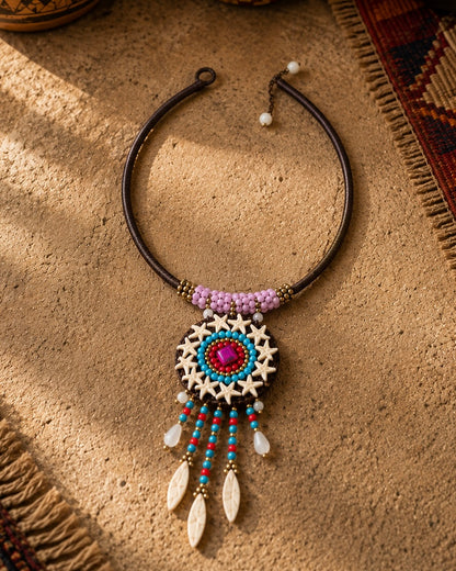 Dettaglio collana etnica con perline turchesi, rosse e ciondolo centrale