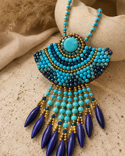 Collana boho turchese con maxi ciondolo indossata in un ambiente mediterraneo in stile Ibiza.