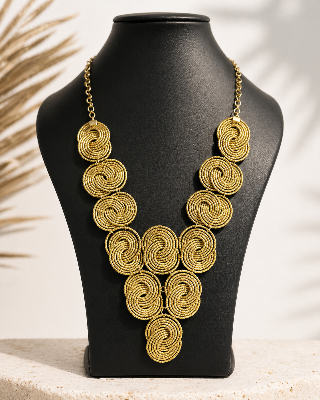 Collana Capim Dourado su busto nero con design a dischi intrecciati dorati