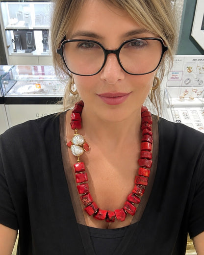 Collana in corallo bambù rosso con perle barocche naturali indossata da donna.