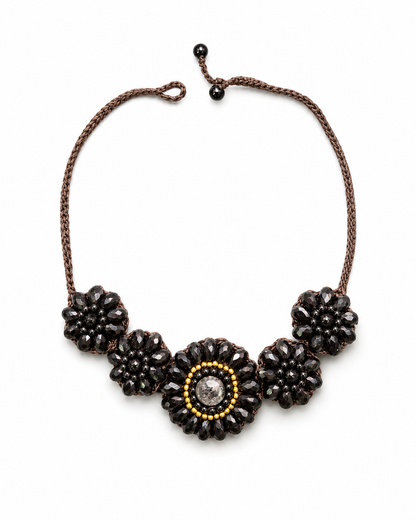 Collana artigianale Fiore Noir con cinque fiori in cristalli neri e cordoncino intrecciato regolabile.