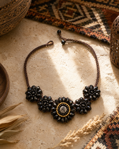 Dettaglio della collana Fiore Noir con cristalli neri sfaccettati lavorati a mano in stile boho.