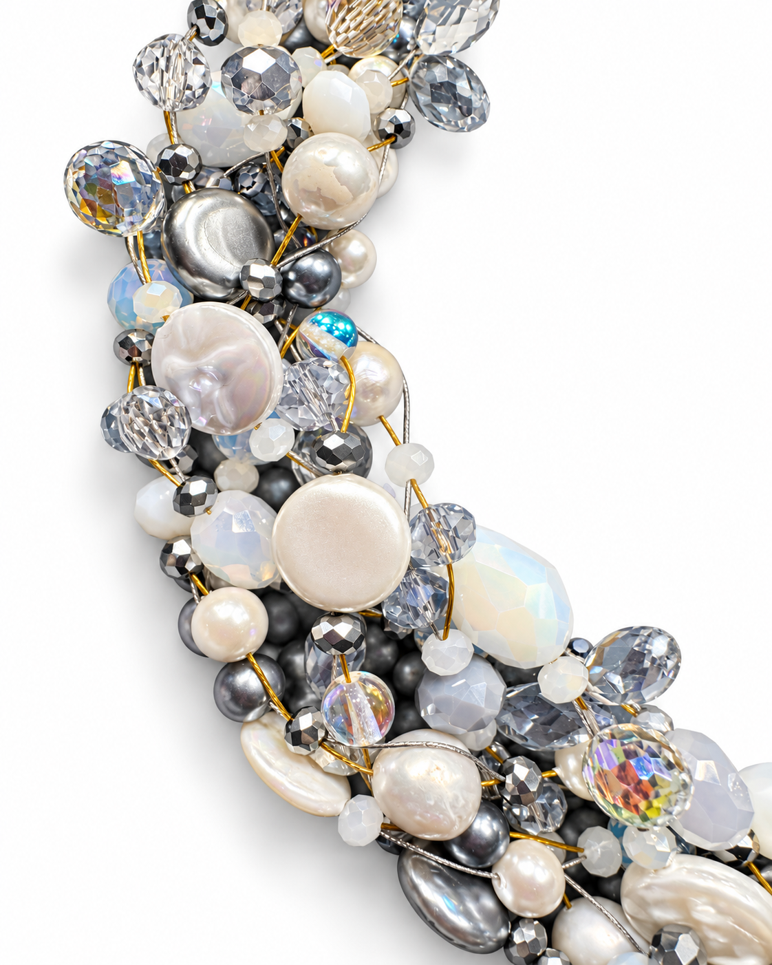 Dettaglio ravvicinato della collana intrecciata artigianale color ghiaccio, con perle naturali, pietre e cristalli luminosi nelle sfumature del bianco, grigio argento e azzurro, su fondo bianco.