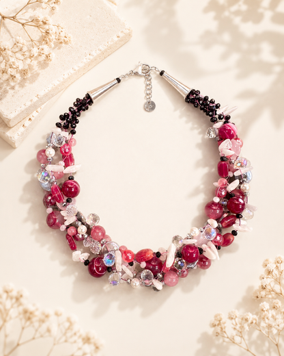 Collana Iconica intrecciata rosa e fucsia con pietre naturali, cristalli e perle luminose.