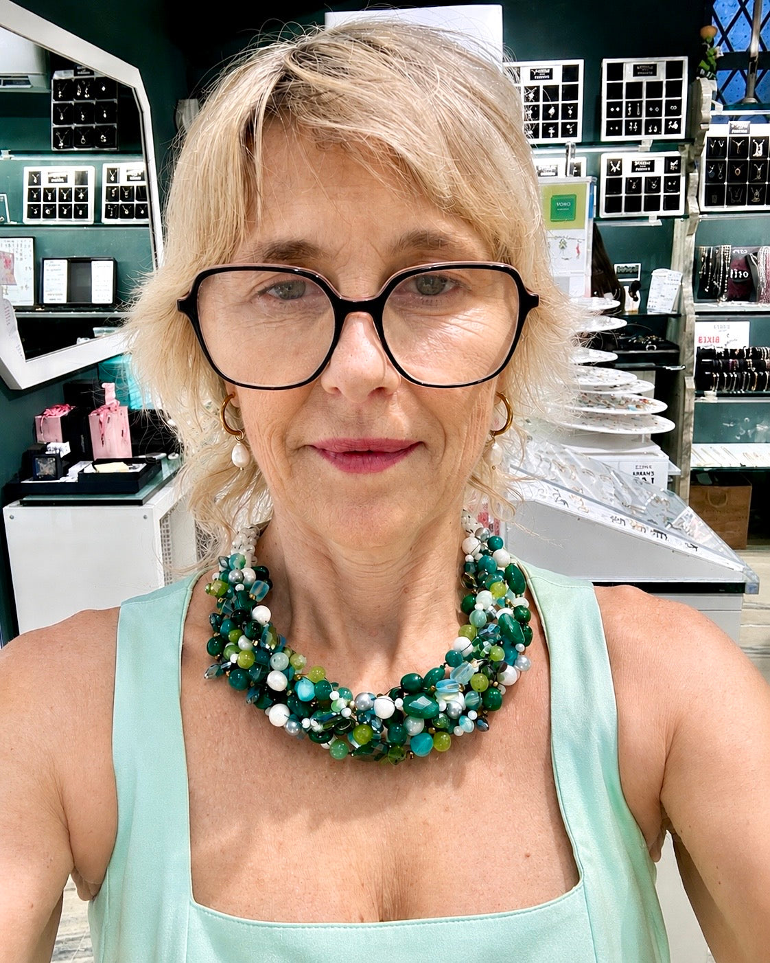 Collana Intrecciata Premium verde menta con pietre naturali, cristalli, perle e finiture in acciaio, indossata.