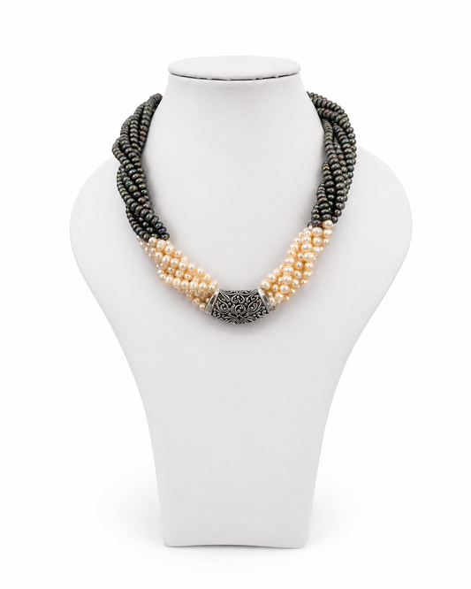 Collana multifilo con perle naturali grigie e avorio, fregio centrale in argento 925 lavorato, elegante design artigianale da donna su sfondo bianco.