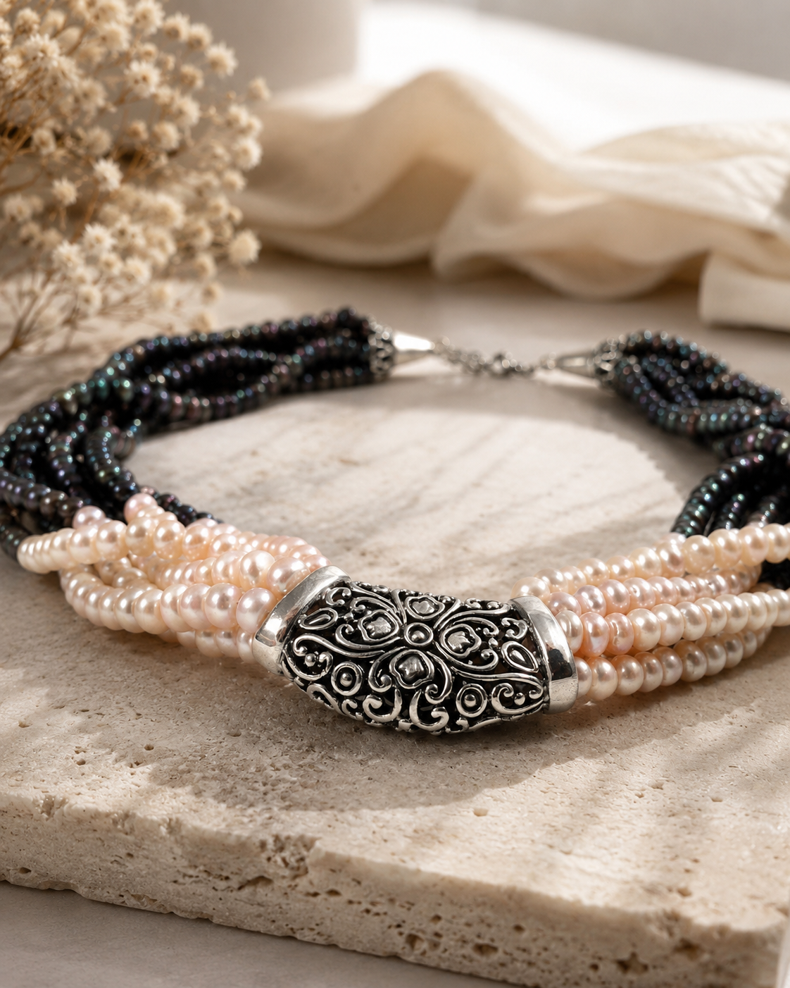 Collana artigianale multifilo con perle naturali grigie e avorio e centrale decorato in Argento 925 ambientata In stile luxury