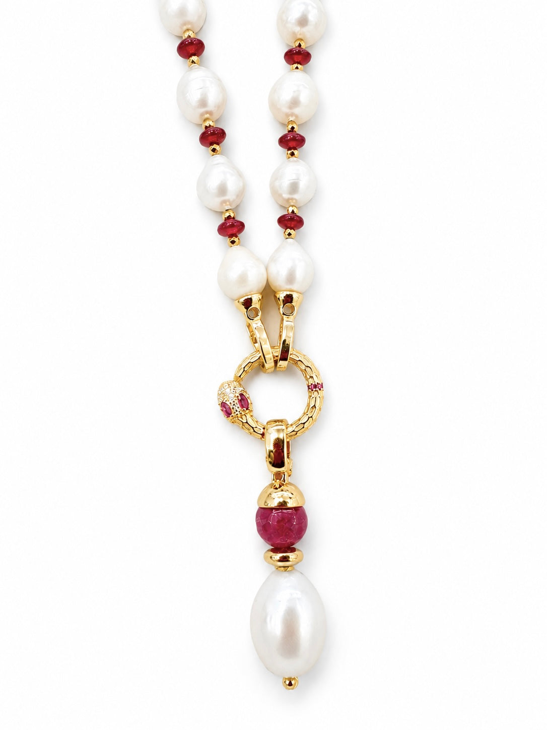 Collana con perle barocche bianche, dettagli rossi e pendente serpente dorato con pietra ruby e perla pendente su sfondo bianco.