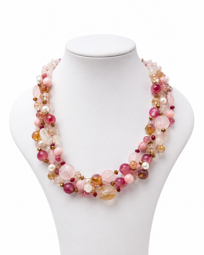 Collana intrecciata con Quarzo Rosa e pietre color melograno su espositore bianco.