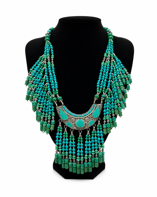 Collana tibetana boho multistrato con perline turchesi e verdi, centrale etnico in metallo argentato e dettagli pendenti in stile artigianale.